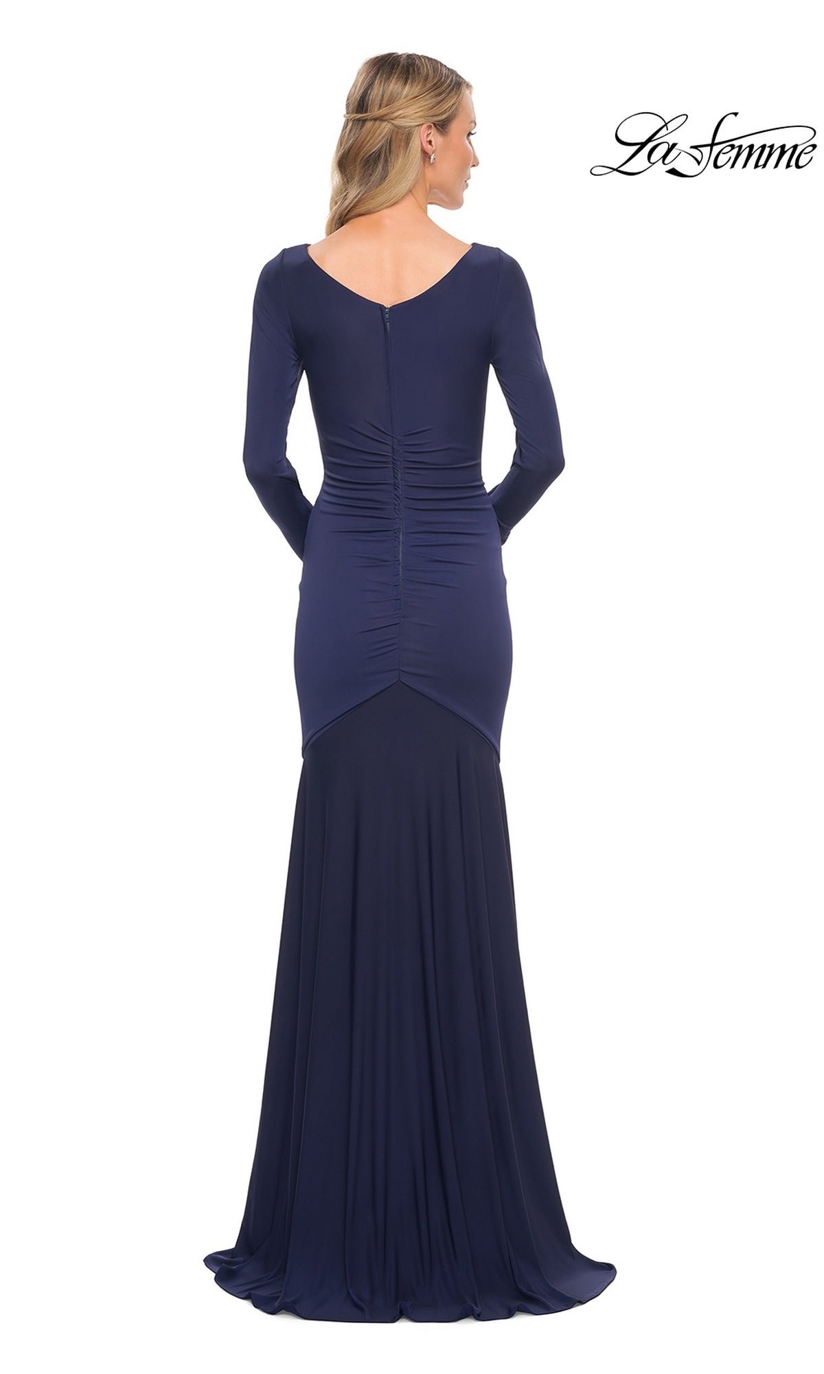 Back view of a woman wearing a navy La Femme 30010 mermaid formal dress with long sleeves and a ruched bodice.